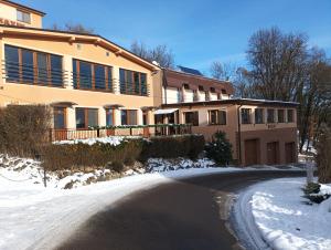 a house in the snow next to a road at Wellness rezort Maxim Bojnice in Bojnice +7 photos