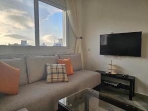 a living room with a couch and a flat screen tv at Corazón Urbano in Martil