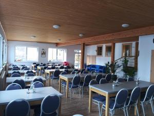 a room full of tables and chairs with blue chairs at Wellness rezort Maxim Bojnice in Bojnice