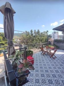 a patio with a umbrella and chairs and tables at Nắng Vĩnh Hy in Ninh Hải