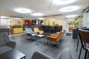 a waiting room with chairs and a bar at Ramada London Stansted Airport in Stansted Mountfitchet