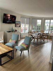 a living room with a couch and a table and chairs at Merville Centre in La Roque-Baignard