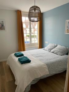 a bedroom with a bed with two towels on it at Merville Centre in La Roque-Baignard