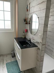a bathroom with a sink and a mirror at Merville Centre in La Roque-Baignard