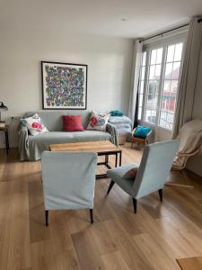 a living room with a couch and a table and chairs at Merville Centre in La Roque-Baignard