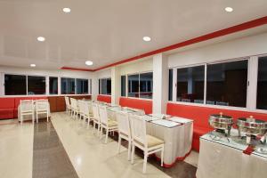 a restaurant with a row of tables and chairs at Hotel MB International in Mysore