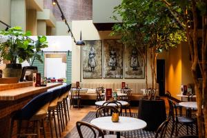 a restaurant with tables and chairs and a bar at City Hotel Gouda, WorldHotels Crafted in Gouda