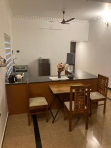 a kitchen with a counter and a table and chairs at The Golden, Apartrooms in Trivandrum +16 photos
