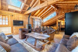 a living room with a table and a tv at Chalet les trois coeurs in Méribel