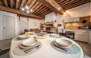 a kitchen and a dining room with a table with chairs at Le Logis Tournusien in Tournus +31 photos