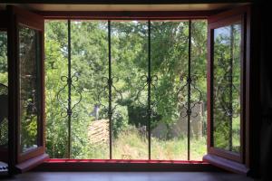 an open window with a view of a forest at Gîte Charlange in Pradelette