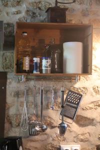 a kitchen counter with cooking utensils on a shelf at Gîte Charlange in Pradelette
