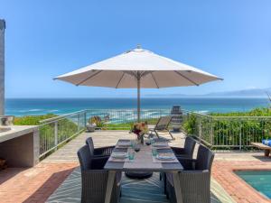 a patio with a table and an umbrella at Walker Bay Villa in Gansbaai