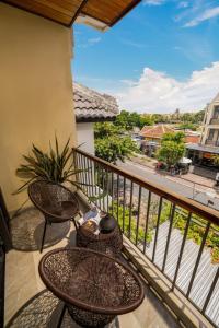 a balcony with tables and chairs and a view of a street at NA Hoian Hotel in Hoi An