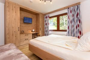 a bedroom with a bed and a window at Hölzl Bed & Breakfast in Neukirchen am Großvenediger