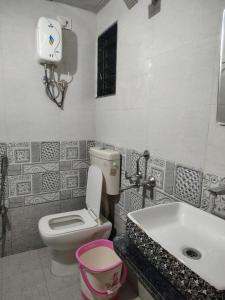 a bathroom with a toilet and a sink at Ganesh Cottage in Matheran