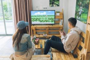 a man and a woman playing a video game in a living room at BG Stone Homestay in Mộc Châu