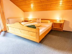 a bedroom with a large wooden bed in a room at Schwarzwaldhotel Schmitz in Todtmoos