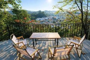 three chairs and a table on a balcony with a view at BG Stone Homestay in Mộc Châu