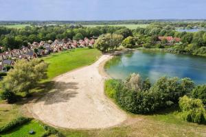 an aerial view of a village next to a lake at 6 - Persons Forest 287 Bungalow in Ewijk +1 photo