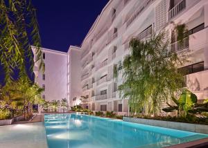 a swimming pool in front of a building at night at Velea Serviced Apartments & Suites in Siem Reap