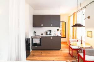a kitchen with a stove and a table with chairs at Entspanntes Design-Studio an der Karli in Leipzig
