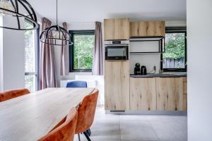 a kitchen and dining room with a wooden table at 6 - Persons Forest 287 Bungalow in Ewijk