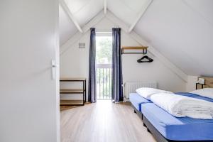 a attic bedroom with two beds and a window at 6 - Persons Forest 287 Bungalow in Ewijk