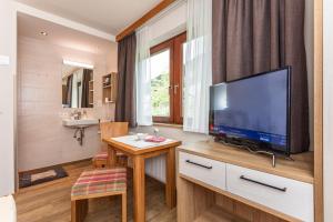 a living room with a television on a wooden table at Hölzl Bed & Breakfast in Neukirchen am Großvenediger +47 photos