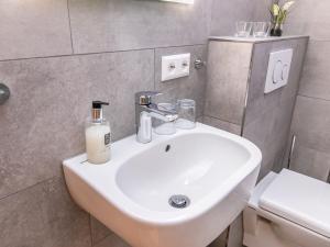 a bathroom with a white sink and a toilet at Schwarzwaldhotel Schmitz in Todtmoos +21 photos
