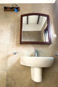 a bathroom with a sink and a mirror on the wall at The Teak Ambalangoda in Ambalangoda