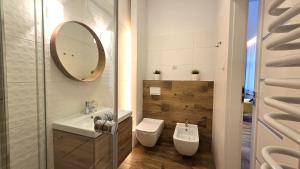 a bathroom with a sink and a toilet and a mirror at Studio - Apartamenty Parkowe in Gniezno