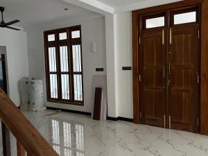 a living room with two doors and a marble floor at SSK Rent Villas in Matara
