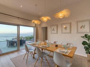 a dining room with a table and chairs and a balcony at Walker Bay Villa in Gansbaai