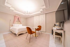a bedroom with a bed and a table and chairs at Den Basta hotel in Yangsan