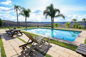 a swimming pool with two chairs and a picnic table at Lodge du Barrage in Rabat