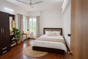 a bedroom with a bed and a desk and a window at Hideout 2bhk Kharadi Near EON in Pune