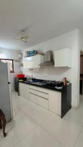 a kitchen with white cabinets and a black counter top at Hideout 2bhk Kharadi Near EON in Pune