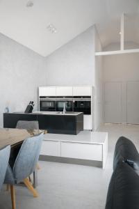 a kitchen with white cabinets and a table and chairs at Chalet Rufux in Dolná Lehota