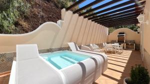 a patio with a hot tub on a house at Balancal Apartments and Villas Palheiro Village by Holiday Rental Madeira in Funchal