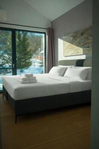 a large bed in a bedroom with a large window at Chalet Rufux in Dolná Lehota