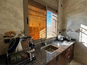 a kitchen with a sink and a window at merzouga apartment in Merzouga
