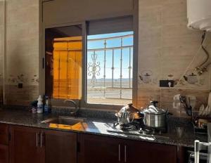 a kitchen counter with a sink and a window at merzouga apartment in Merzouga