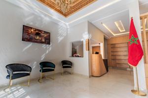a lobby with chairs and a flag on a pole at Hotel Rhali Dakhla in Dakhla