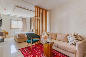 a living room with a couch and a bed at Hotel Rhali Dakhla in Dakhla