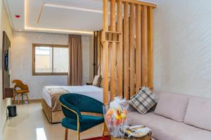 a hotel room with a couch and a bed at Hotel Rhali Dakhla in Dakhla