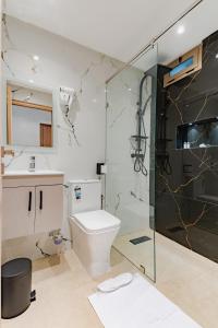 a bathroom with a toilet and a glass shower at Hotel Rhali Dakhla in Dakhla +38 photos