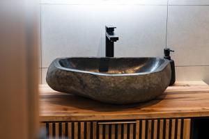a stone sink on a wooden counter in a bathroom at Na Samotě u tratě in Nepomuk