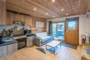 a kitchen and living room with a couch and a table at Appartement Marmotte in Méribel
