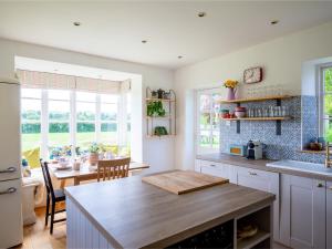 a kitchen with a table and a dining room at Corn Close in Stretton on Fosse